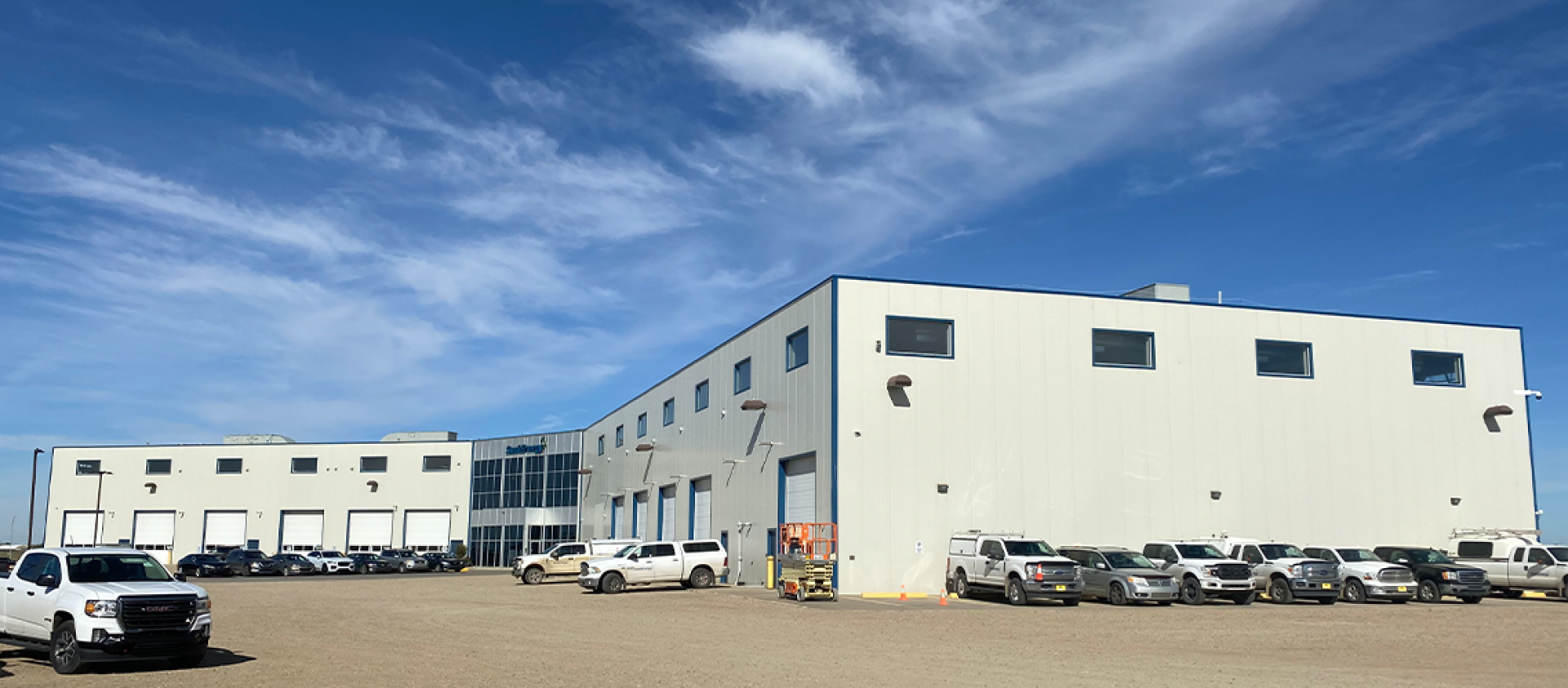 A wide-shot view of the Regina Service Centre building in fall, with blue sky above.
