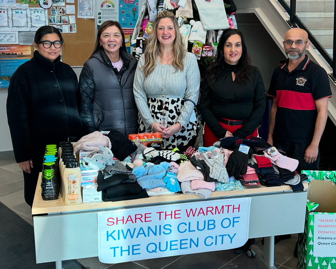 Five people stand in front of donated items