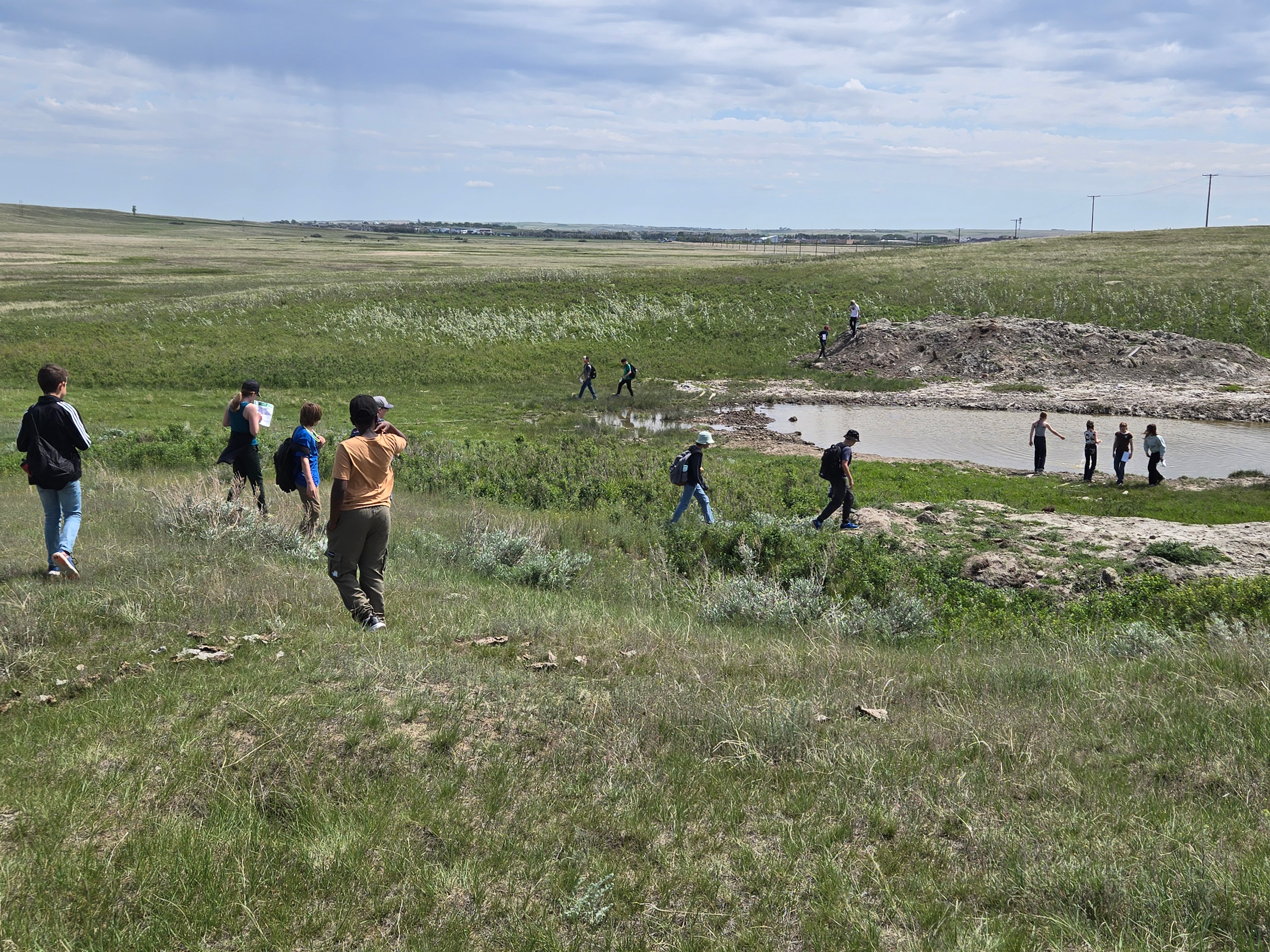 Hikers walking through prairie land.