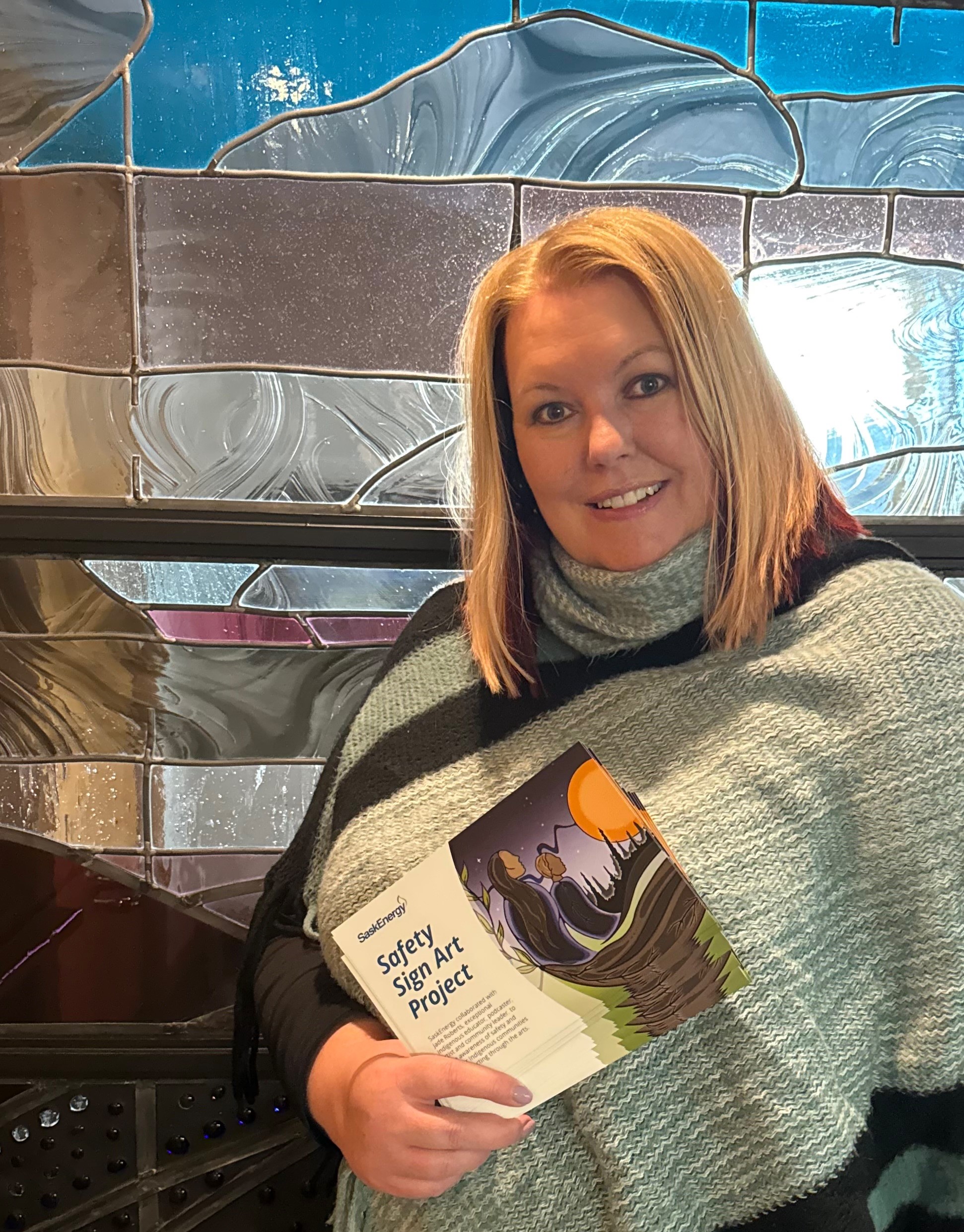 SaskEnergy employee holding handouts displaying the new artwork.