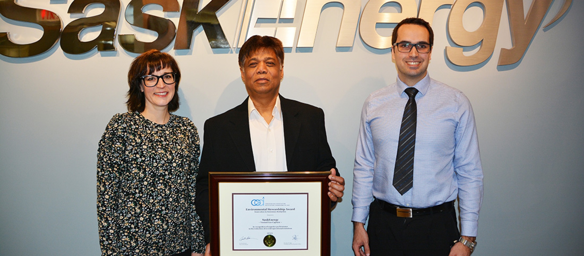 saskenergy employees stand with CGA award