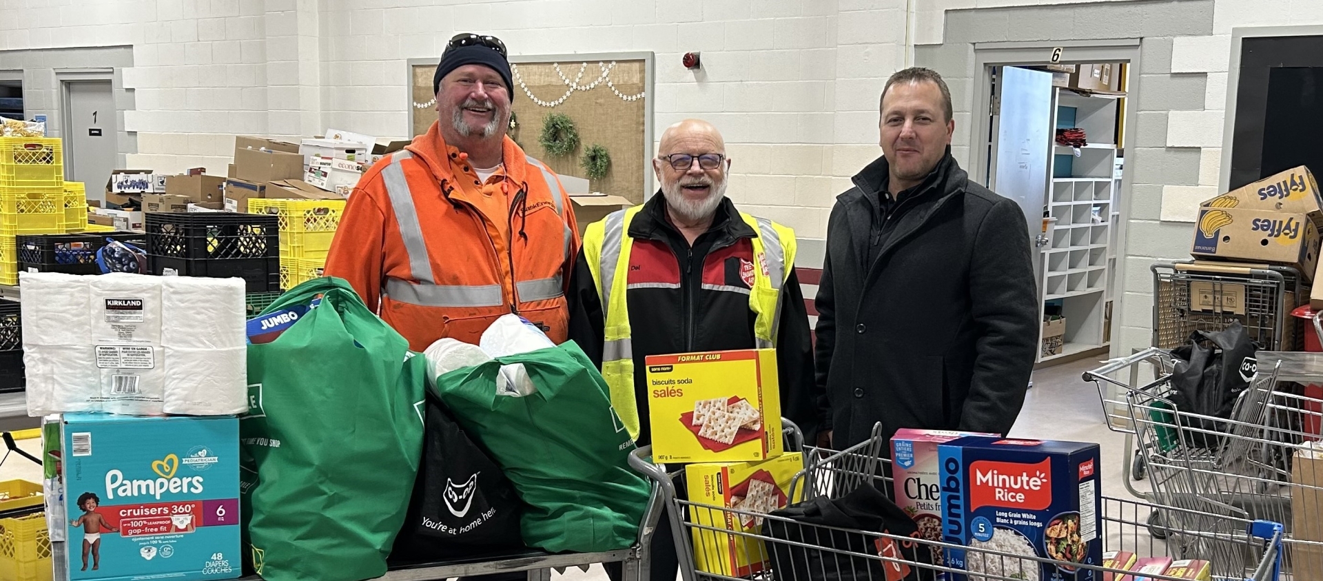 Three people pose in a food bank