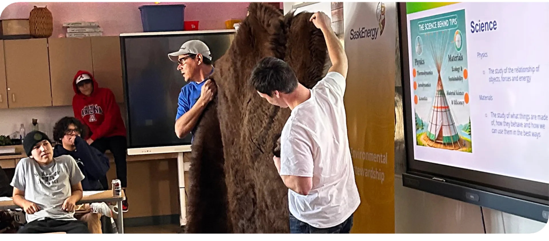 Two men holding up a buffalo hide