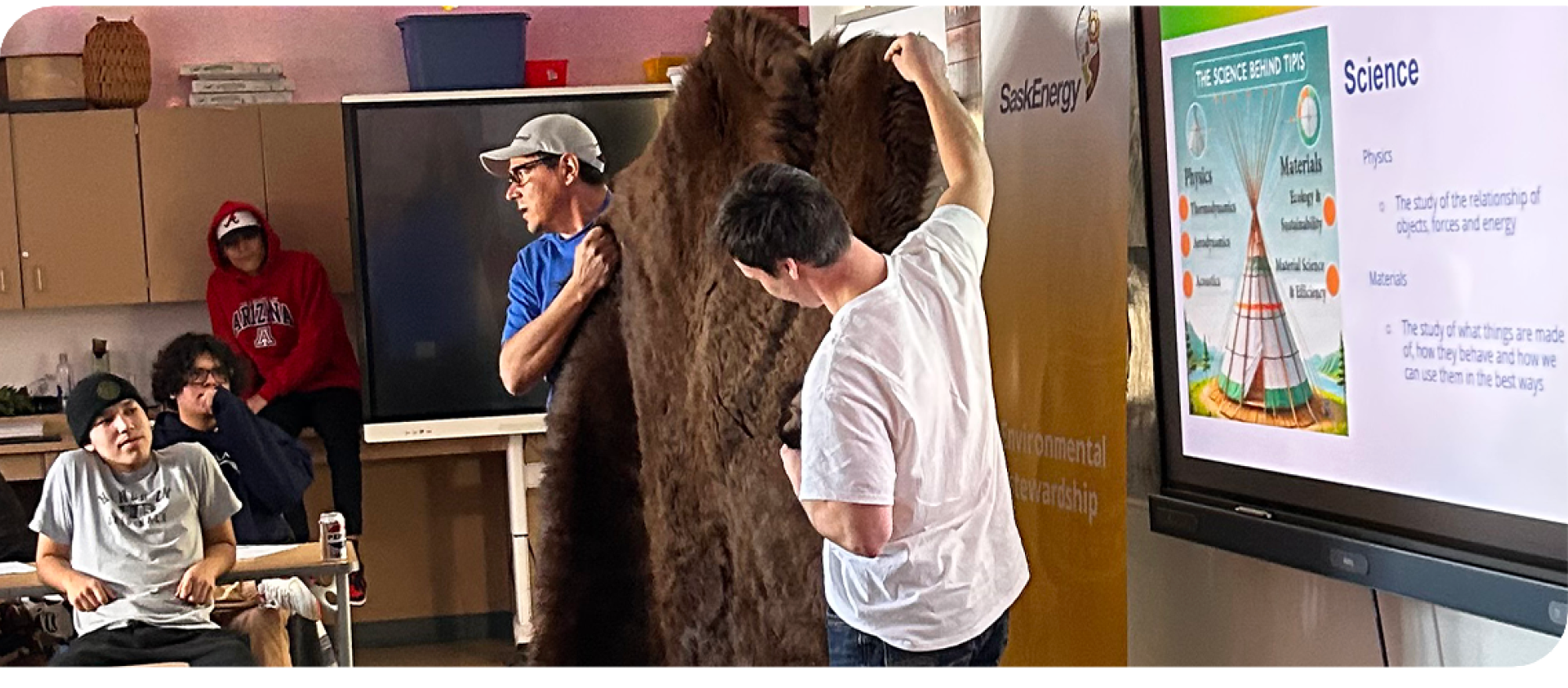 Two men holding up a buffalo hide