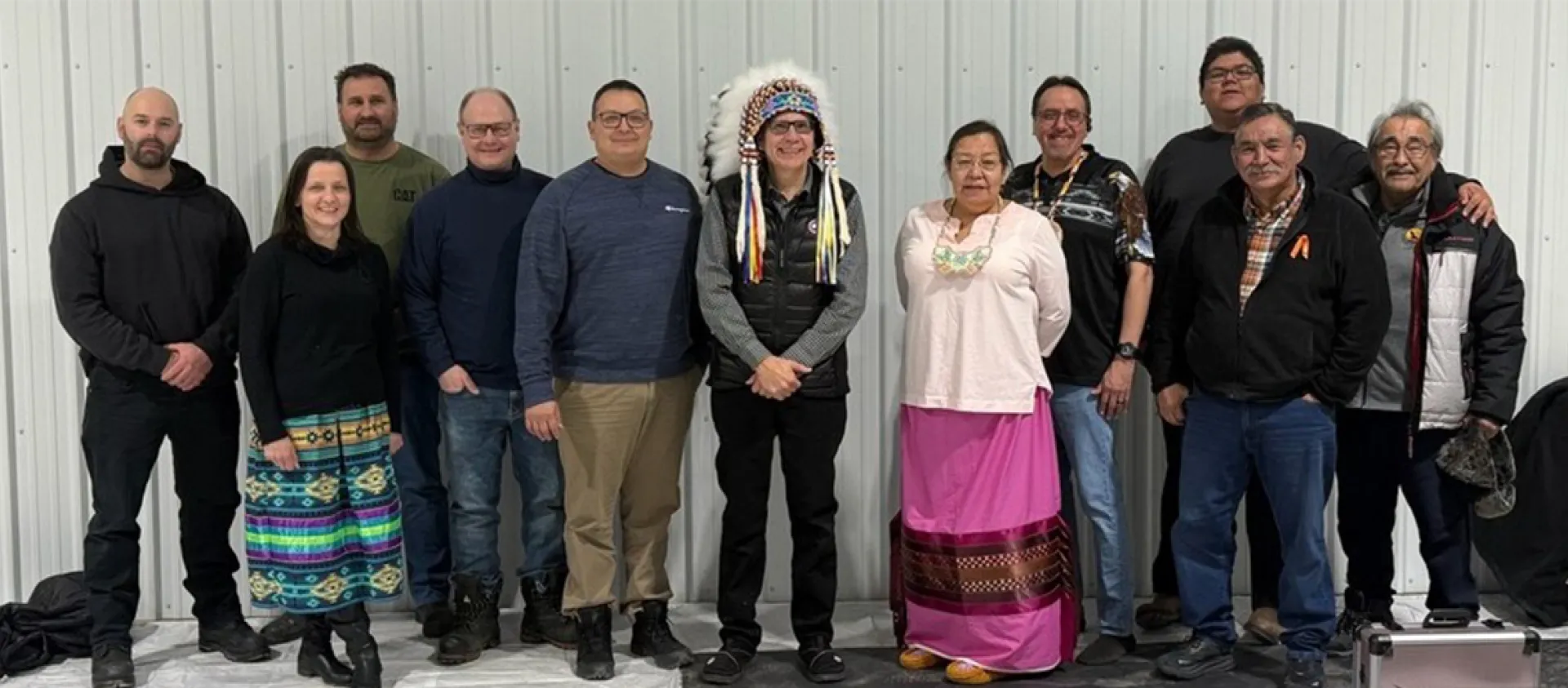 A group of SaskEnergy employees and members of the Peter Chapman Band pose together for a photo.