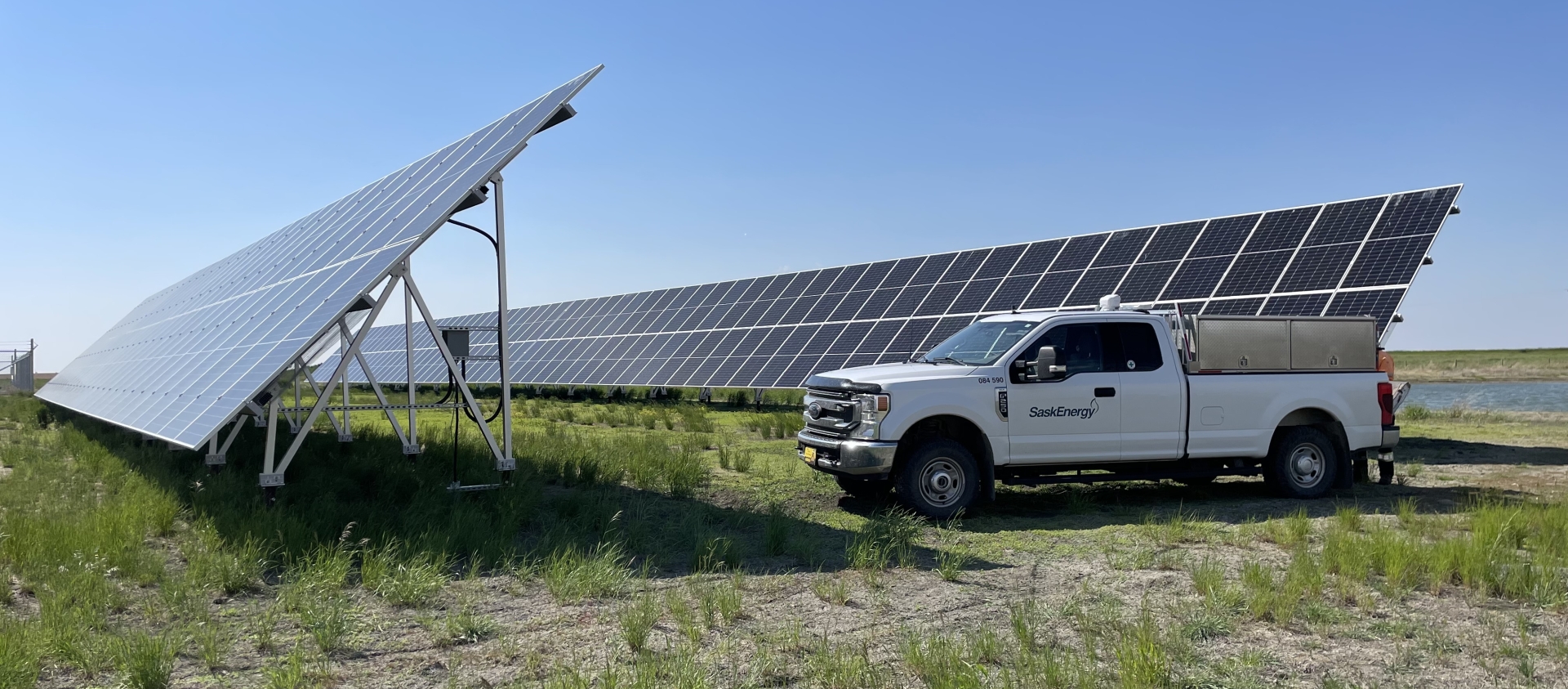 Solar panels at SaskEnergy's Rosetown Compressor Station. SaskEnergy truck parked by solar panels on a sunny day.