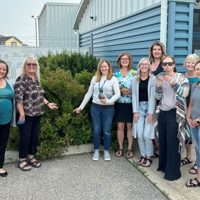 A group of SaskEnergy employees in Weyburn pose next to a bush that a duck made her nest in