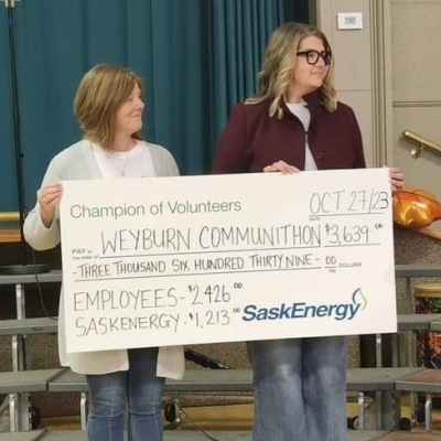 Two people holding a large cheque. 