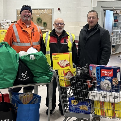 Three people pose in a food bank