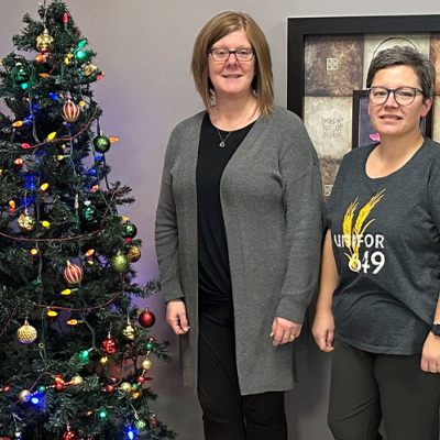 Four people stand near a Christmas tree
