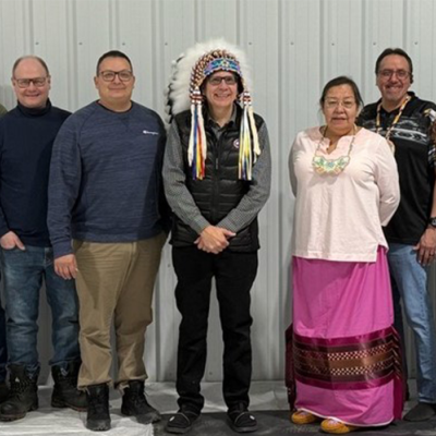 A group of SaskEnergy employees and members of the Peter Chapman Band pose together for a photo.