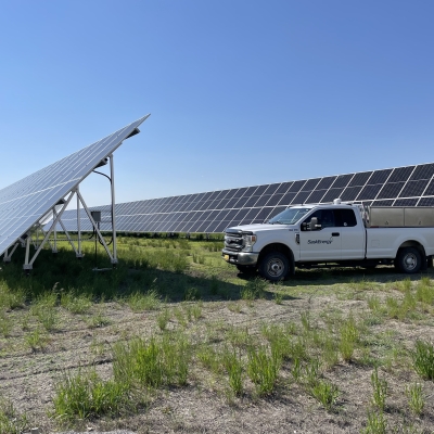 SaskEnergy truck parked by solar panels on a sunny day.