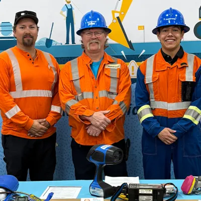 Employees in safety gear posing for a photo