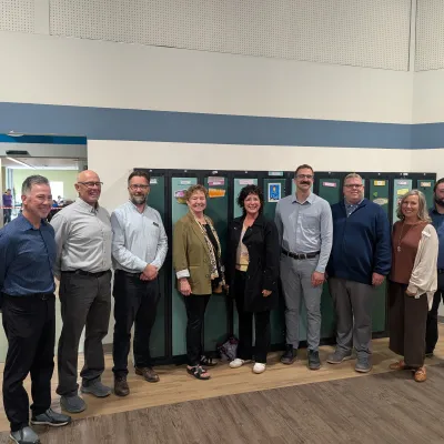 A group of people pose for a photo while touring a community organization.