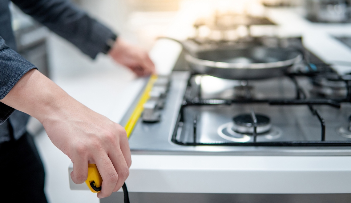 person measuring a stove