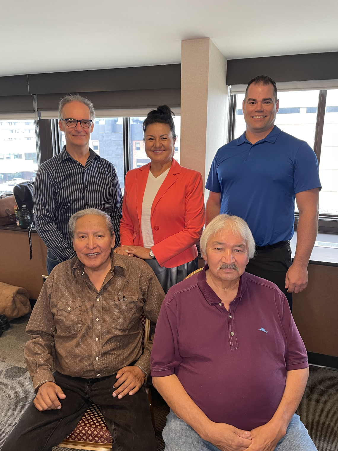 Five people pose in a banquet room