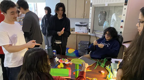 Students building object out of paper plates
