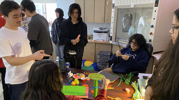 Students building object out of paper plates