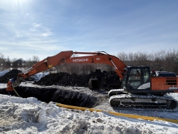 Heavy equipment works near open natural gas line trench