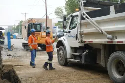 A SaskEnergy dump truck prepares to unload backfill at a construction site.