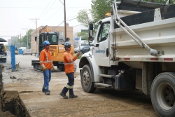 A SaskEnergy dump truck prepares to unload backfill at a construction site.