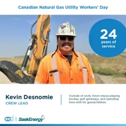 SaskEnergy construction worker with heavy equipment in background.