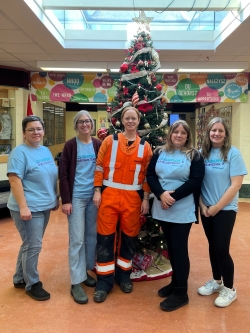 Employees posing in front of a tree