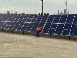 A SaskEnergy employee stands in front of the solar panels installed at the Regina Town Boarder Station #3