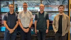 Four men stand in front of a stained glass window - Taylor, Kyle, Devin and David, all engineers at SaskEnergy.