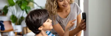 Mom and son adjusting thermostat