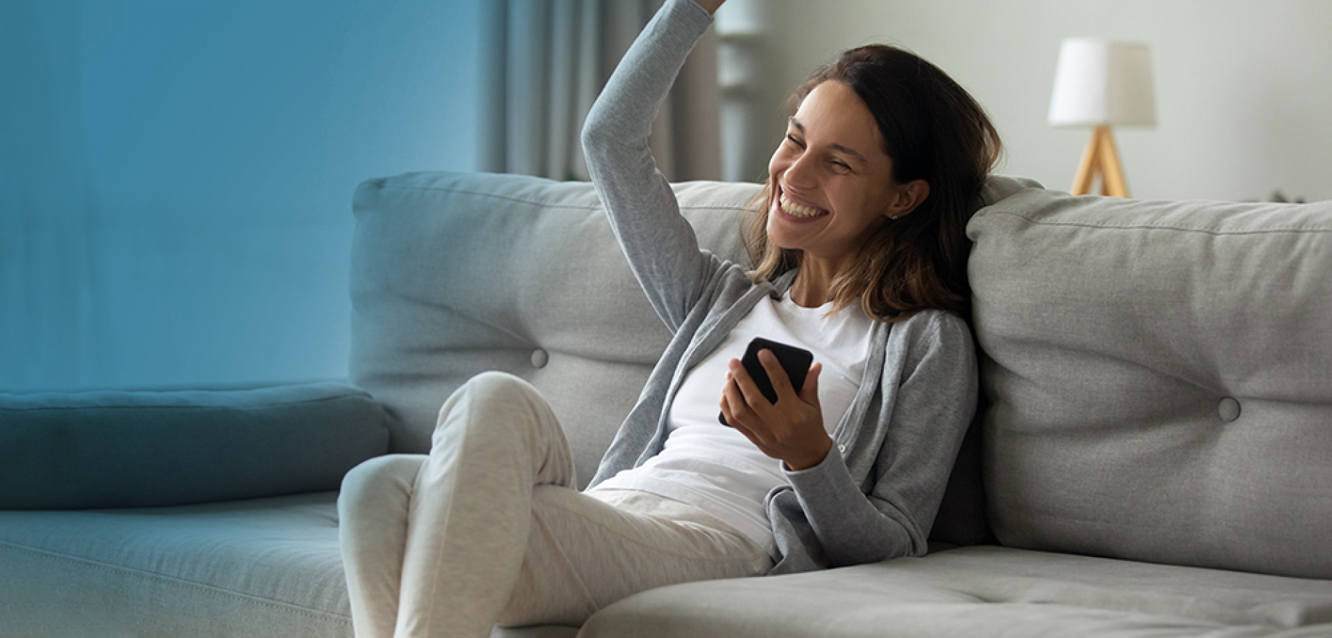 Happy woman on couch with phone