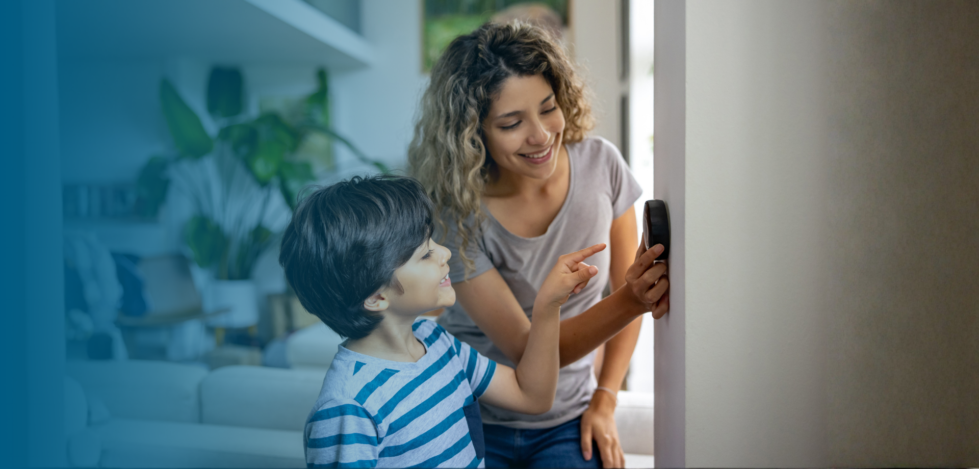 woman and son turning down thermostat together