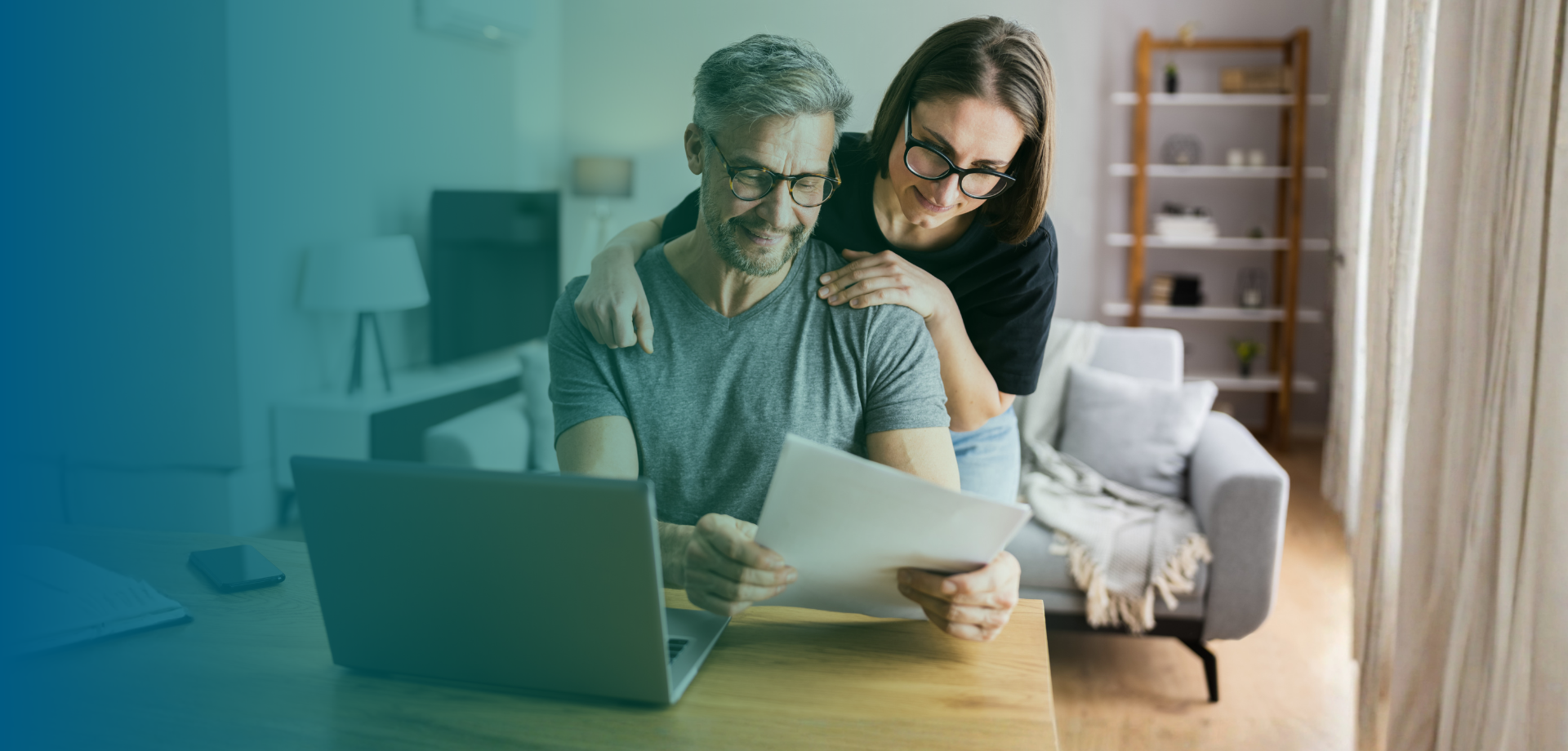 Couple looking at papers and computer